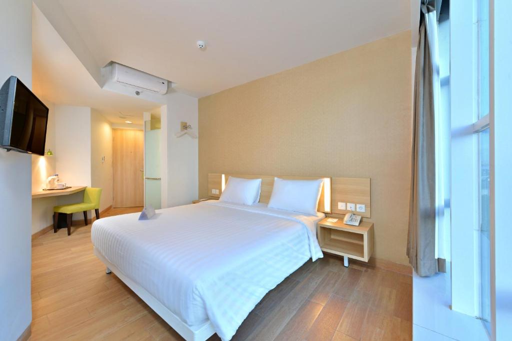 Postel nebo postele na pokoji v ubytování Whiz Prime Hotel Hasanuddin Makassar