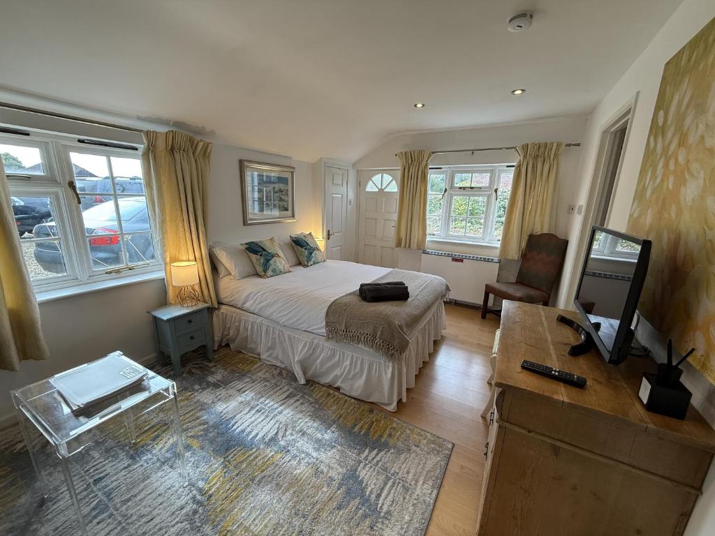 a bedroom with a bed and a television in it at The Guesthouse Hideaway by Newfo.rest in Hordle