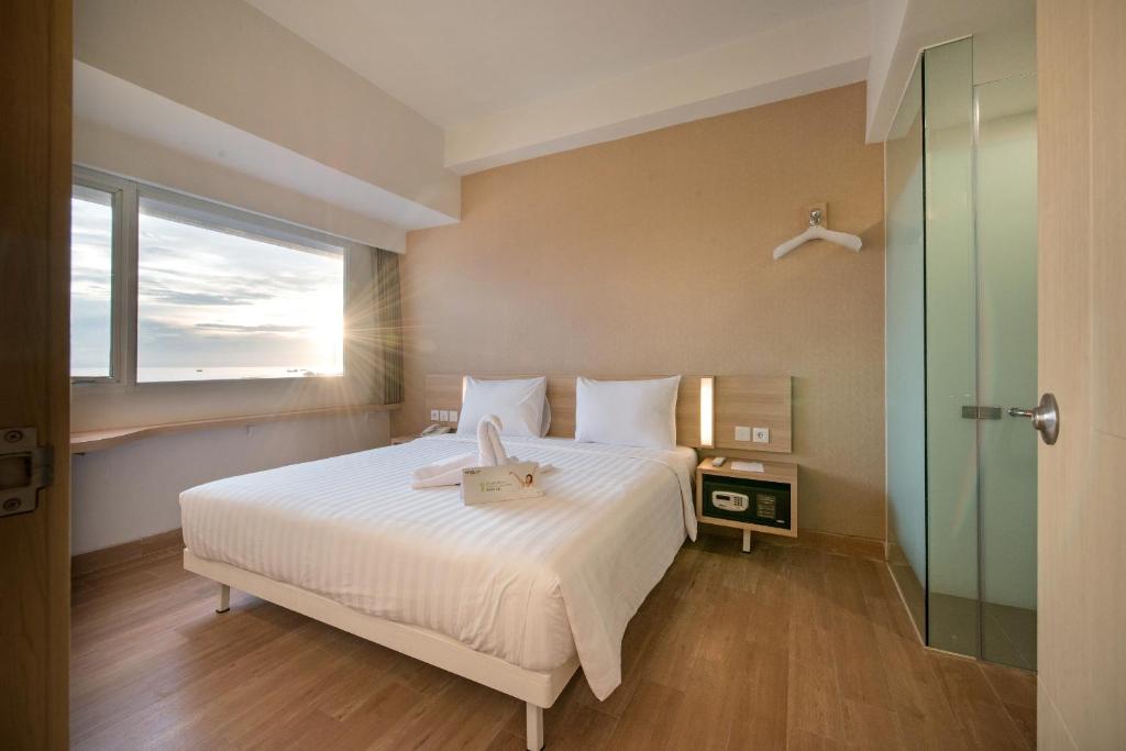 Postel nebo postele na pokoji v ubytování Whiz Prime Hotel Hasanuddin Makassar