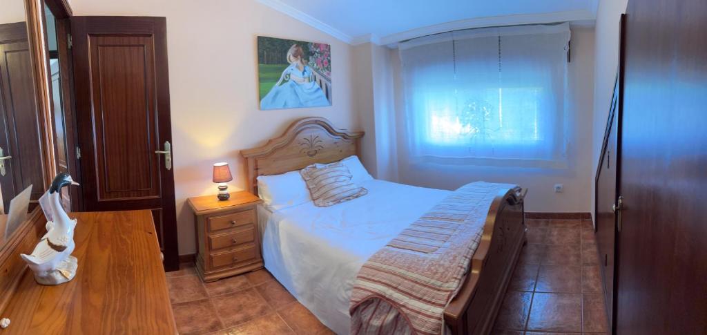 a small bedroom with a bed and a night stand at CASA A BARCELA en San Vicente de O Grove in San Vicente de O Grove