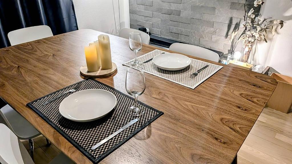 a dining room table with two white plates and two candles at UND STAY Premium Luxury Vacation 別府 鉄輪 in Beppu