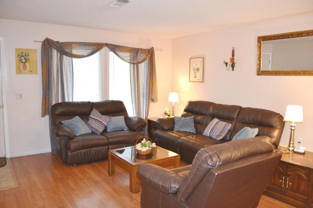 un soggiorno con un divano in pelle e un tavolo di 5 Vaqueria Lane a Hot Springs Village