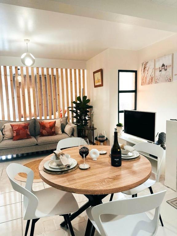a living room with a wooden table and white chairs at Dani House - Porto Moniz Escape in Porto Moniz
