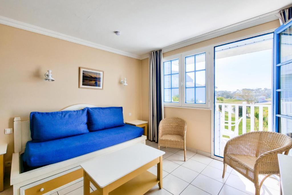 un salon avec un canapé bleu et un balcon dans l'établissement Résidence Port Bourgenay - maeva Home - Appartement 2 pièces 6 personnes - Prestige MAE-8821, à Talmont-Saint-Hilaire