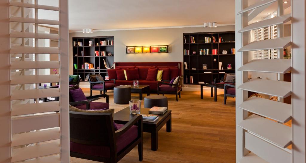 a living room with a red couch and chairs at Hotel Wetterstein in Munich
