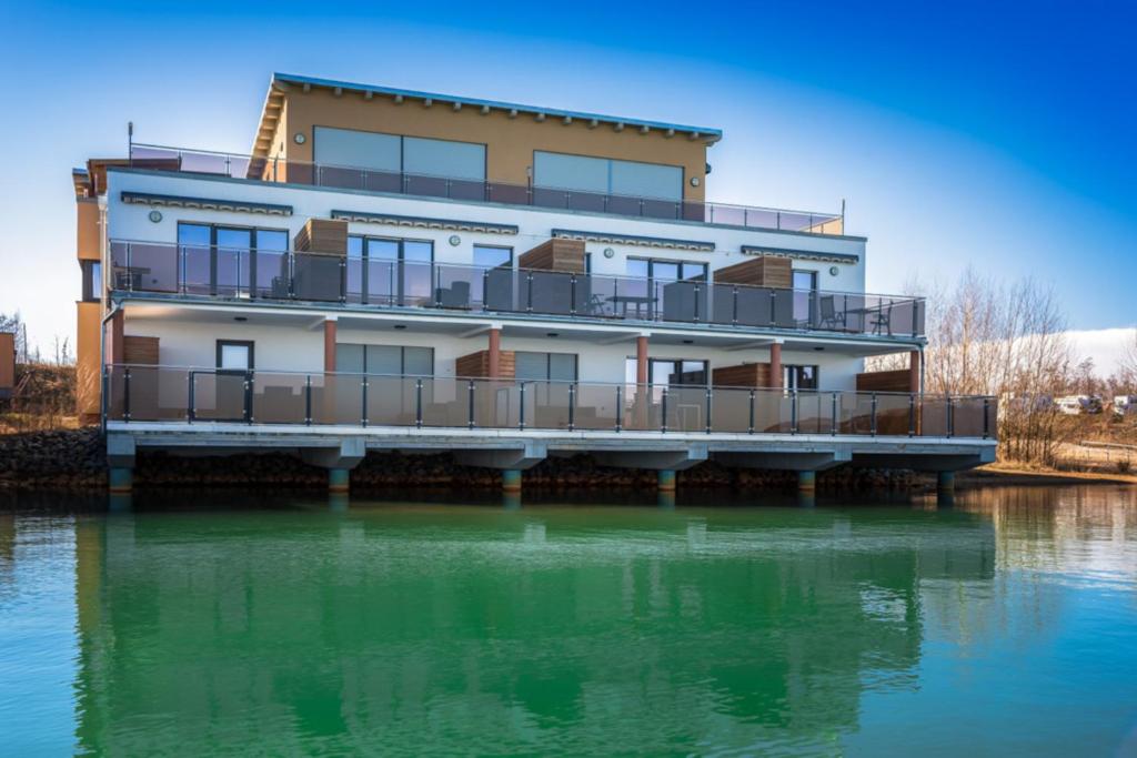 a building on a pier on the water at LAGOVIDA Kapitänskajüte e am Störmthaler See in Großpösna