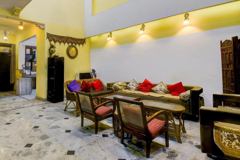 a living room with a couch and tables and chairs at Super Hotel O Sikar Road Jaipur Formerly Garg Niwas in Jaipur