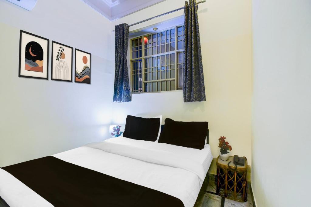 a bedroom with a white bed and a window at Super Hotel O Sikar Road Jaipur Formerly Garg Niwas in Jaipur