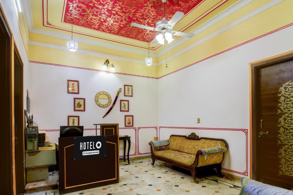 a living room with a couch and a ceiling at Super Hotel O Sikar Road Jaipur Formerly Garg Niwas in Jaipur