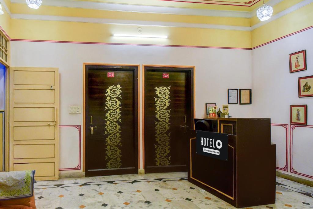 a room with two glass doors and a desk at Super Hotel O Sikar Road Jaipur Formerly Garg Niwas in Jaipur