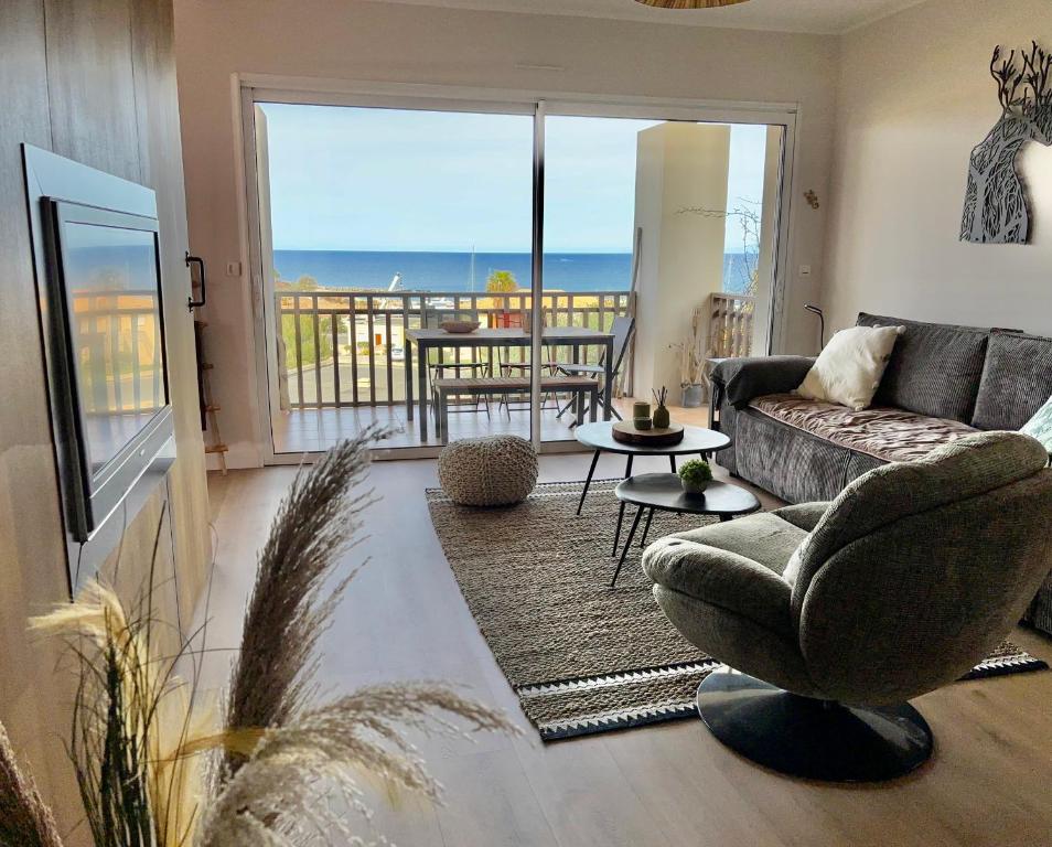 a living room with a couch and a view of the ocean at A 3 PAS DE LA PLAGE DE SANT'AMBROGGIO in Lumio