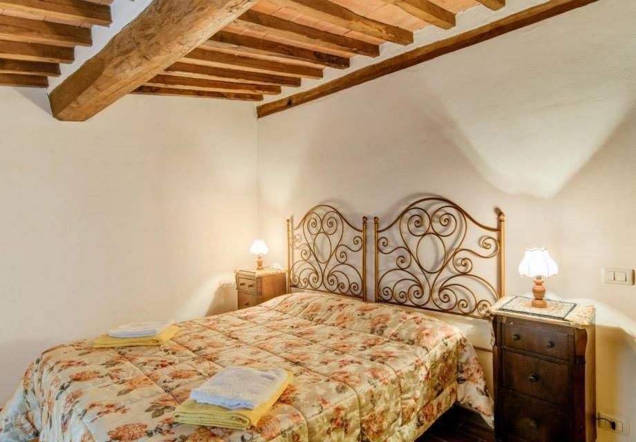 トッリータ・ディ・シエーナにあるCase dei Fiori Residenza Storicaのベッドルーム1室(ベッド1台、ドレッサー、ランプ2つ付)