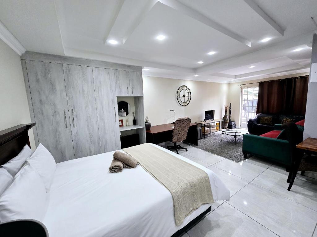 a bedroom with a large bed and a living room at Waterfall City Guest Lodge in Sandton
