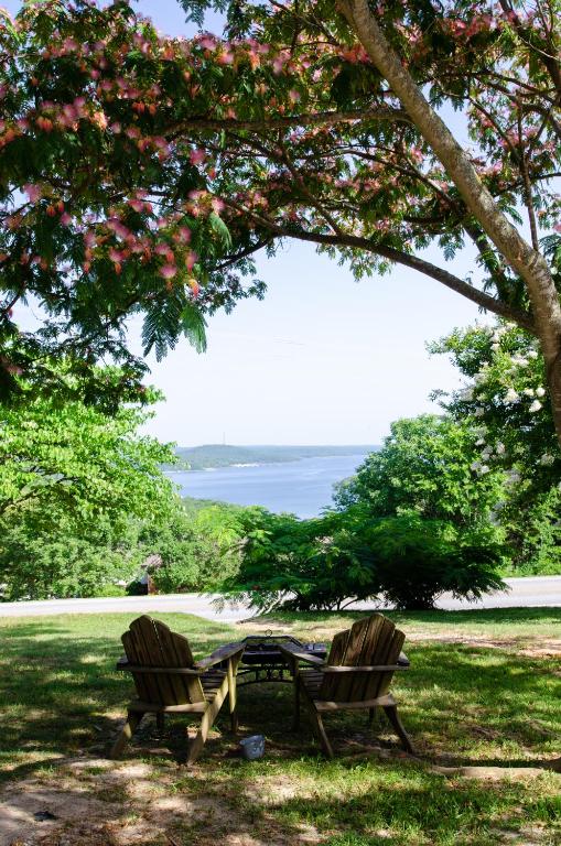 two chairs and a picnic table under a tree at Whispering Woods Cabins & Grill in Jordan