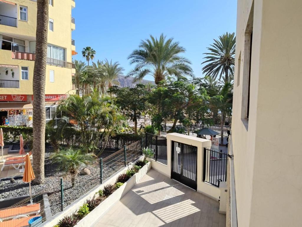 a balcony of a building with palm trees at Joy and Friends 2 El Carmen in Los Cristianos