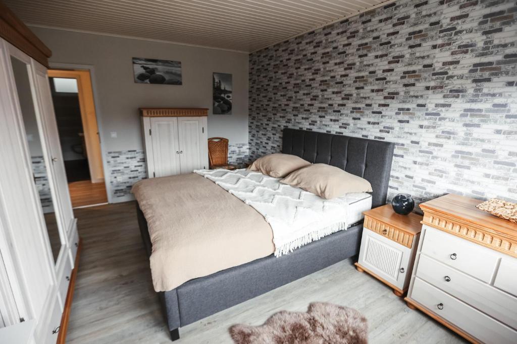 a bedroom with a large bed and a brick wall at Ferienwohnung Rose in Walkenried