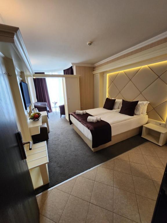 een hotelkamer met een bed en een woonkamer bij Park Hotel Plovdiv in Plovdiv