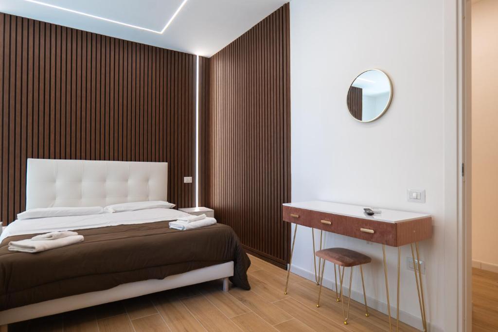 a bedroom with a bed and a vanity and a mirror at Relais San Demetrio - Modern & Central rooms in Salerno