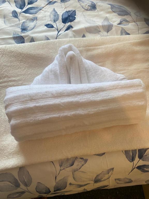 a bed with white towels on top of it at Deluxe Studio Coventry in Parkside