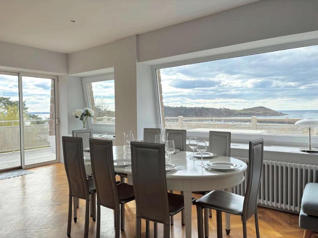 une salle à manger avec une table et des chaises et une grande fenêtre dans l'établissement Résidence H06-trebeurden - Villa vue mer plage et coucher de soleil MAE-3444, à Trébeurden