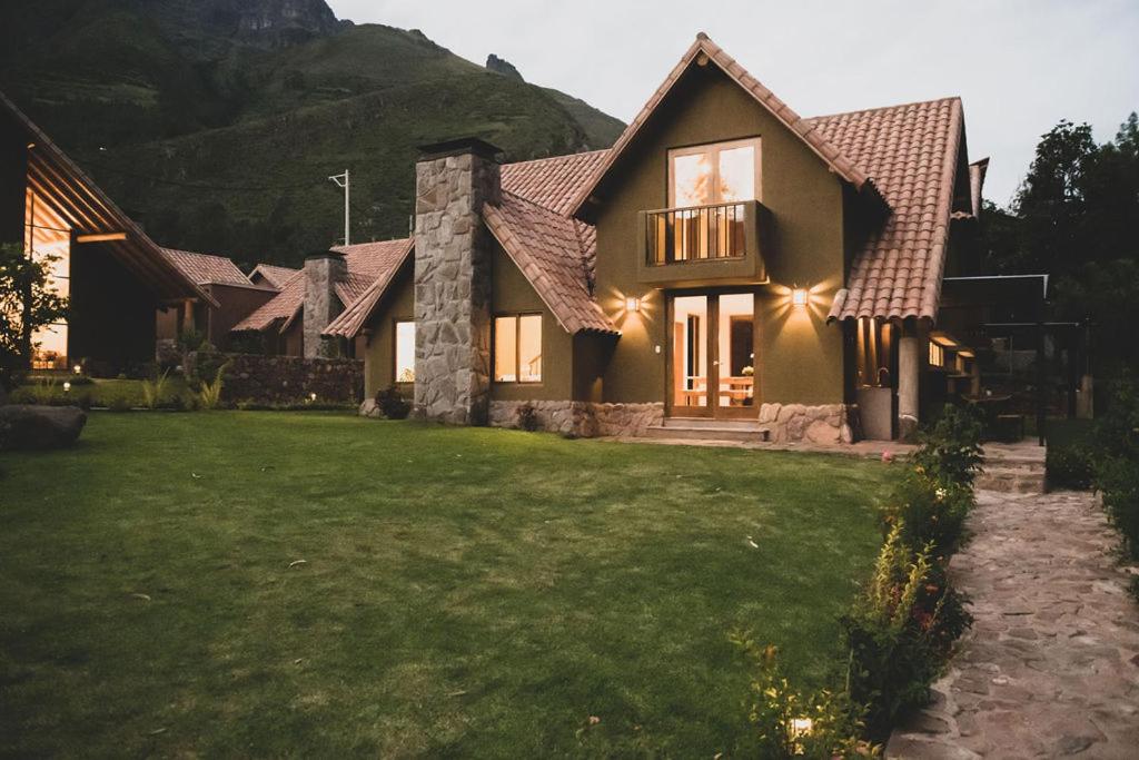 a house with a green lawn in front of it at Villas del Valle Sagrado in Cusco