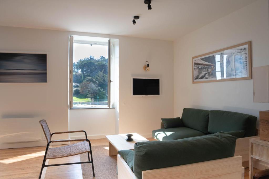 - un salon avec un canapé vert et une chaise dans l'établissement Les Hyades,port de Dahouët, à Pléneuf-Val-André