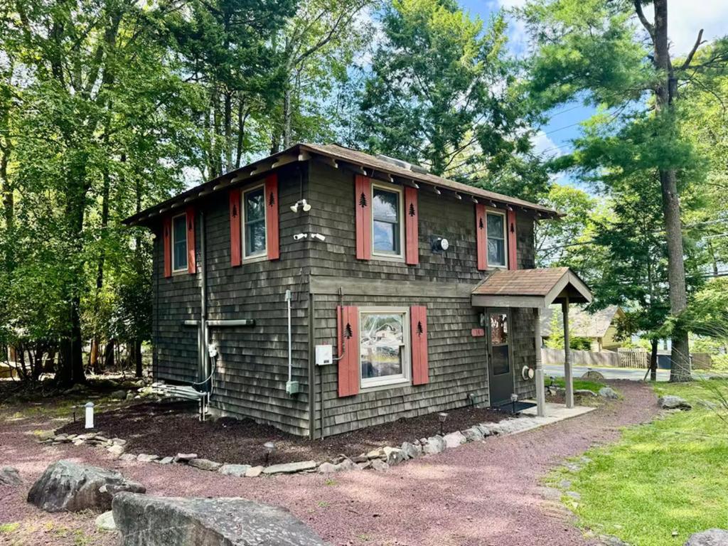 ein kleines Haus mit roten Rollläden drauf in der Unterkunft Cozy Cottage, Private Lake Access, Fires and Fun! in Lake Harmony