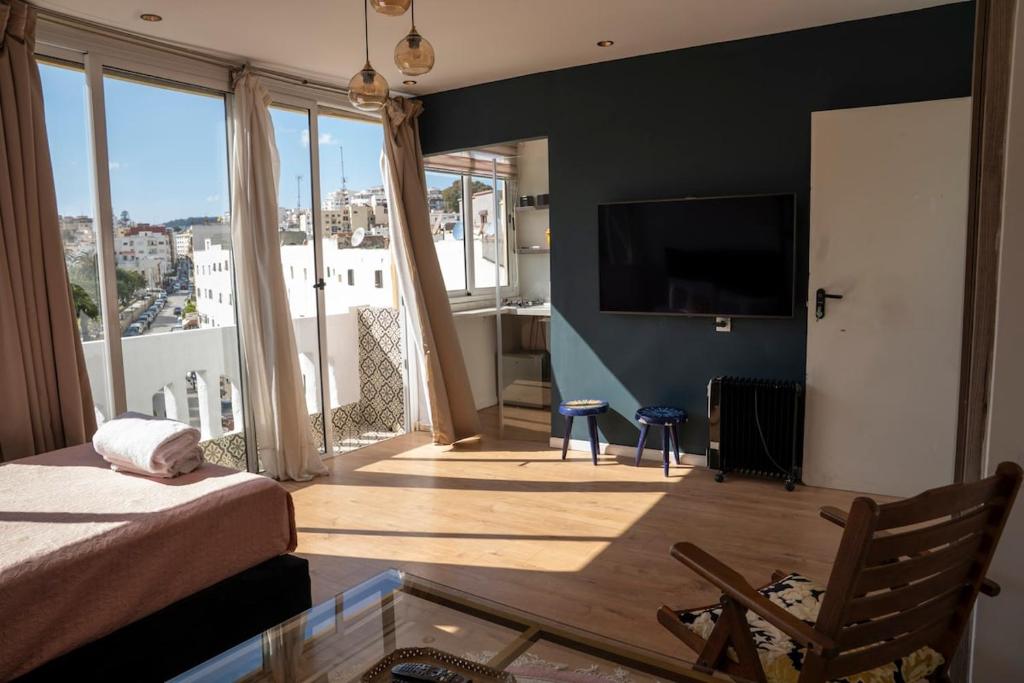a living room with a bed and a large window at Ba Sidi, Estudio in Tangier