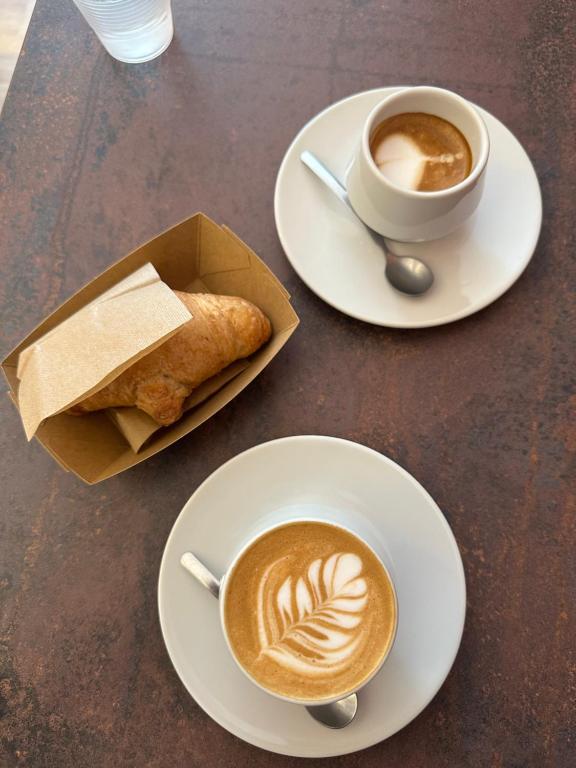 Una mesa con dos tazas de café y un pastel. en Trullo Diaz Fanizza, en Alberobello