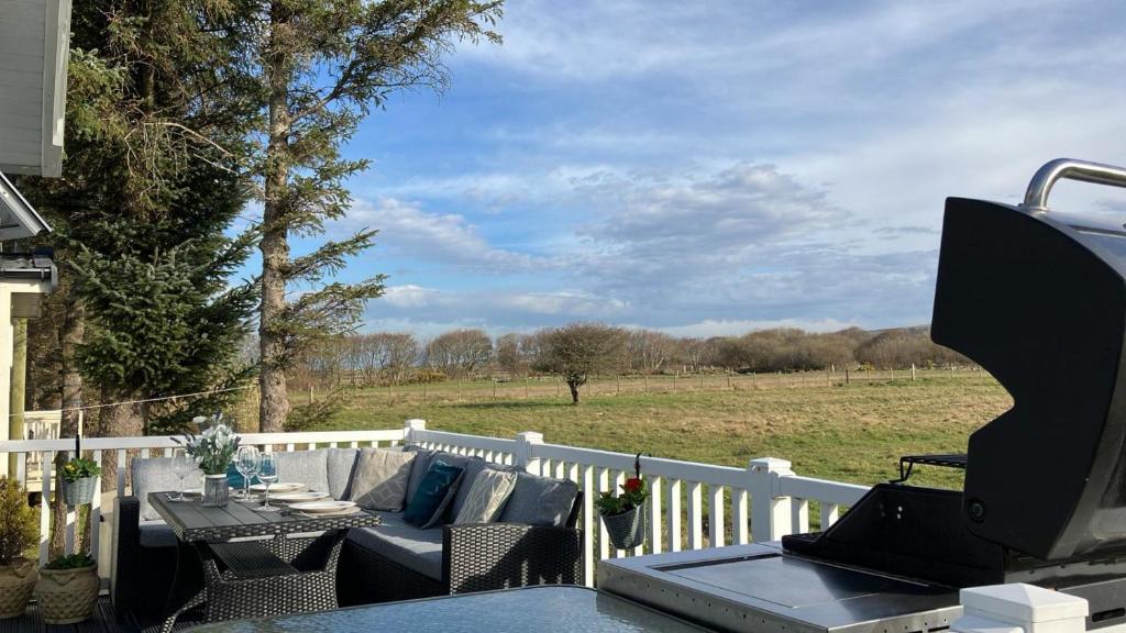 a patio with a table and chairs on a white fence at Barmouthbay209 in Barmouth