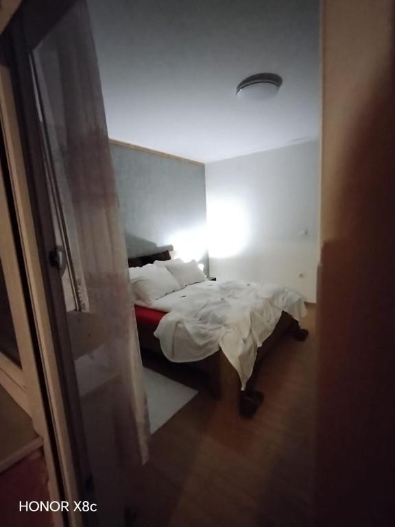 a small bedroom with a bed with white sheets at Sobe "Mira",Lipovac -Bajakovo in Lipovac