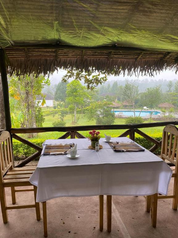 un tavolo con una tovaglia bianca e due sedie di Andasibe Sifaka Lodge a Andasibe