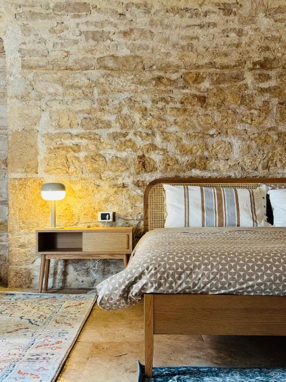 a bedroom with a bed and a brick wall at Il Magazzeno della Prozia in Corato