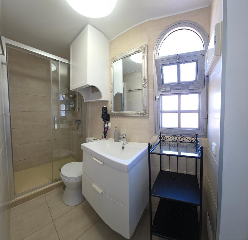 a bathroom with a sink and a toilet and a window at Holiday house Fuerteventura in Costa Calma