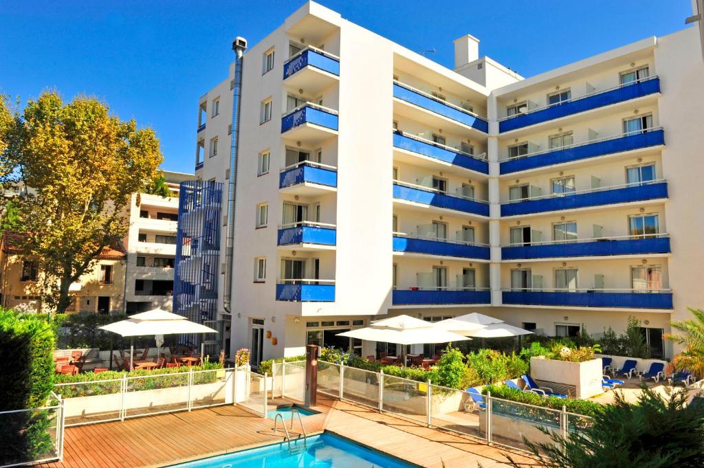 a hotel with a swimming pool in front of a building at Appart'hôtel Goélia Sun City in Montpellier