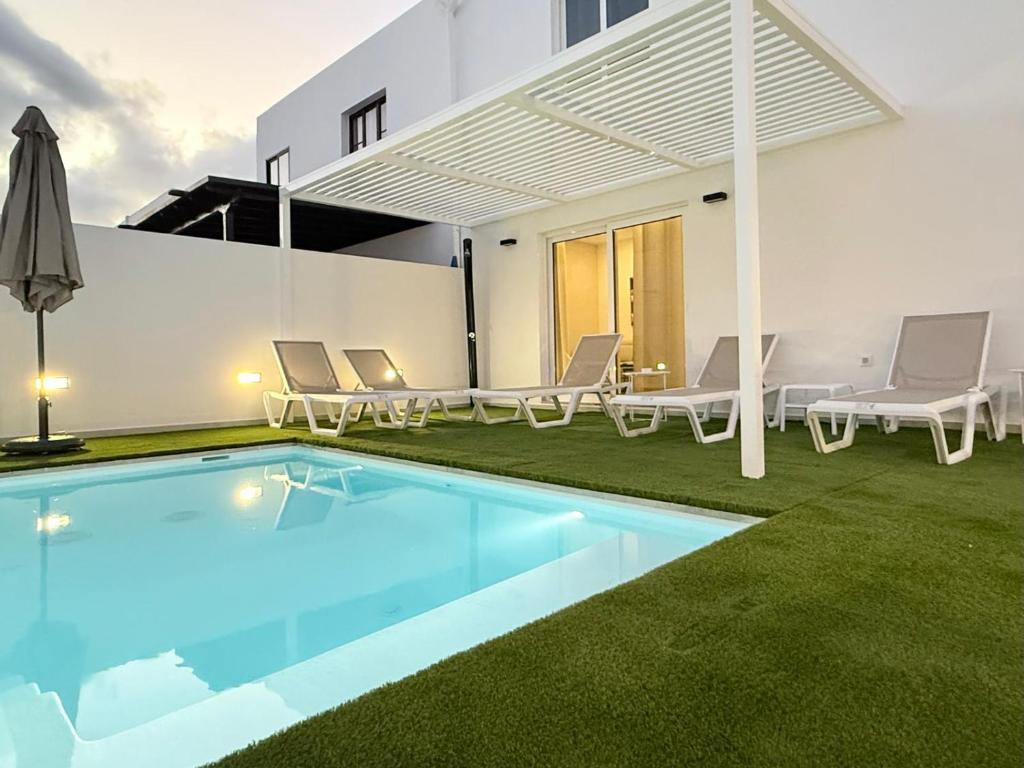 a villa with a swimming pool and a house at Villa Tiffany in Puerto del Carmen