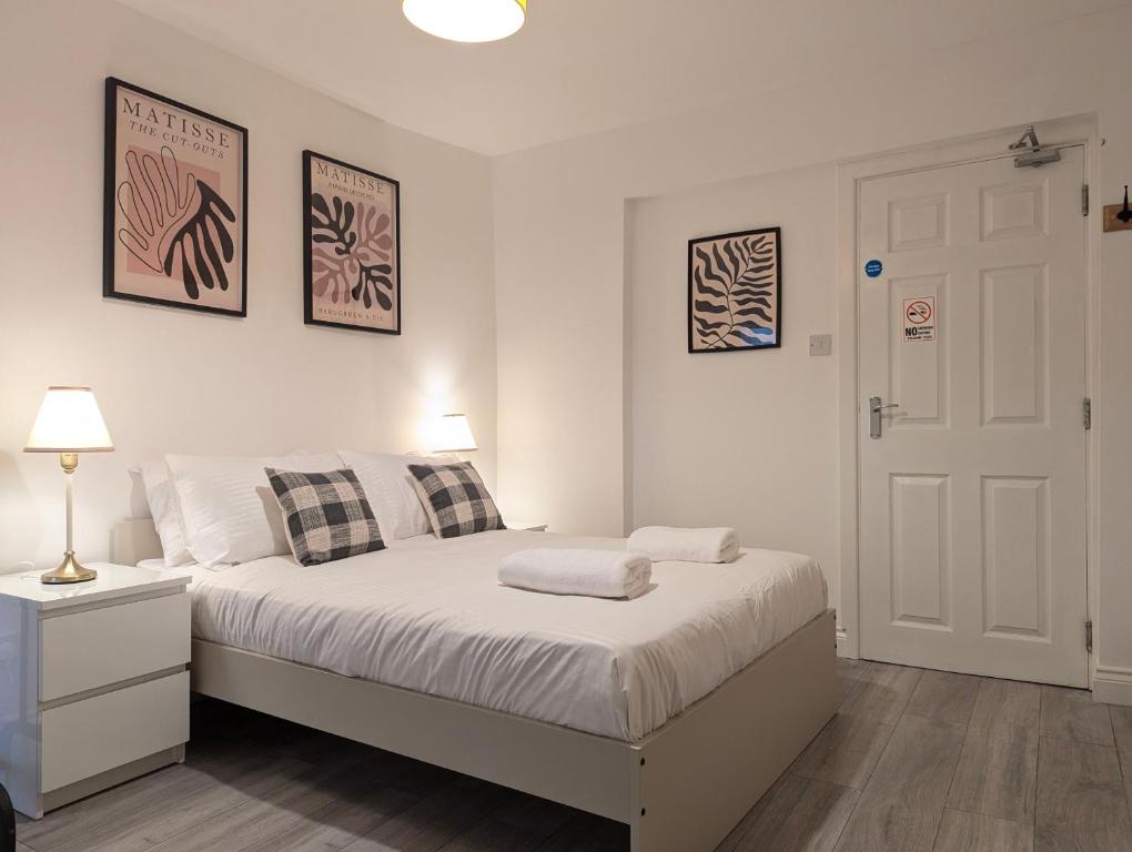 a white bedroom with a bed and a white door at Modern Apartment Near Manchester City Centre in Manchester