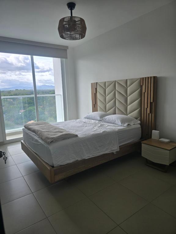una camera da letto con un letto grande e una grande finestra di Apartamento en Playa Corona Ph Patricia Italia a La Chumicosa