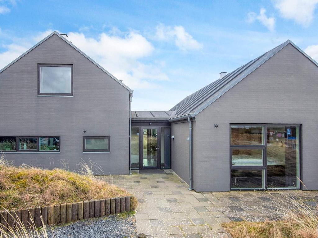 een grijs huis met grote ramen en een oprit bij Luxury Panoramic Cottage in Rindby-By Traum in Fanø