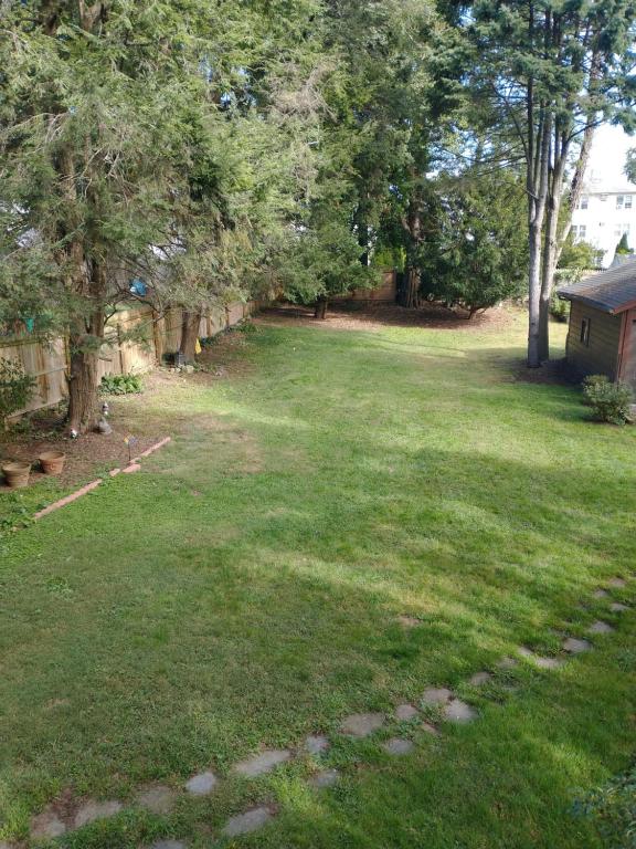 a yard with green grass and trees and a house at 2 Bedroom Unit and Big Yard 30 Minutes to NY in Ridgefield Park