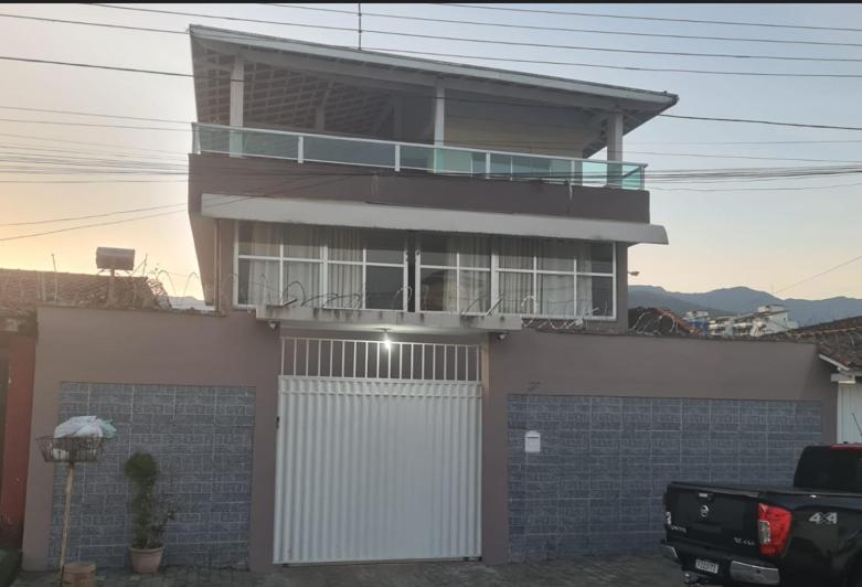 a house with a balcony on top of it at Martin de Sá - Casa da Olivia in Caraguatatuba