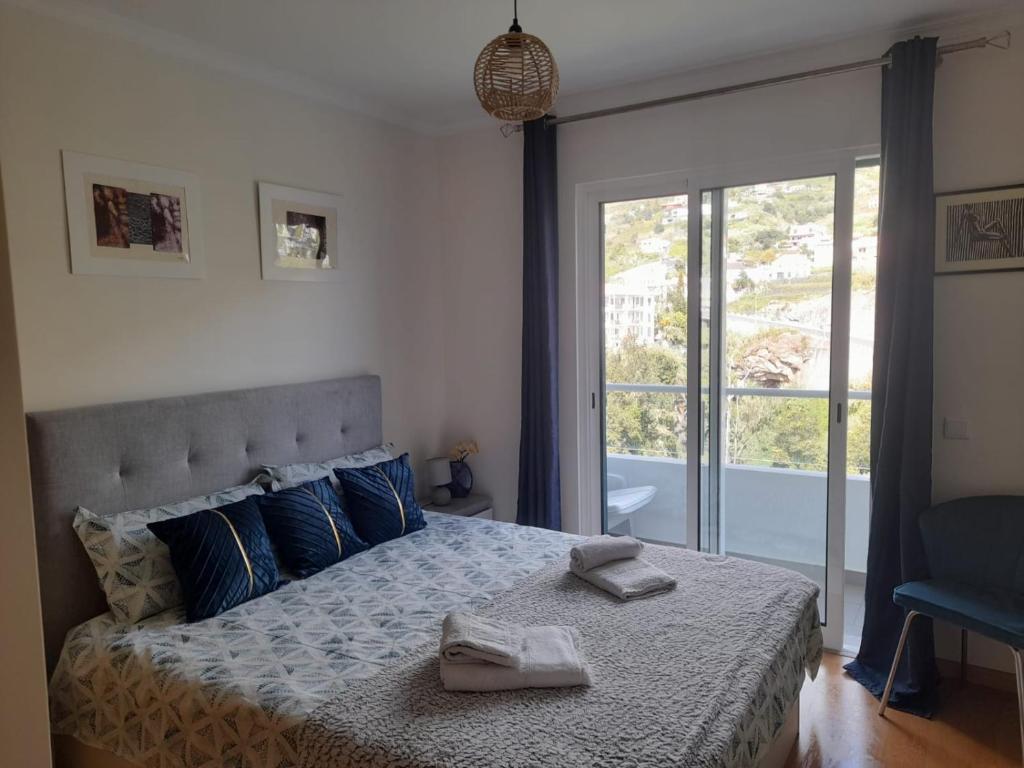 Un dormitorio con una cama con dos toallas encima. en Art House Madeira I, en Caniço