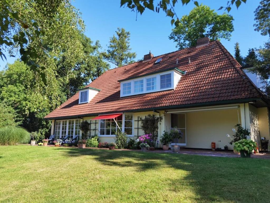 a house with a red roof and a yard at Holiday home with 4 bedrooms in Fischerhude