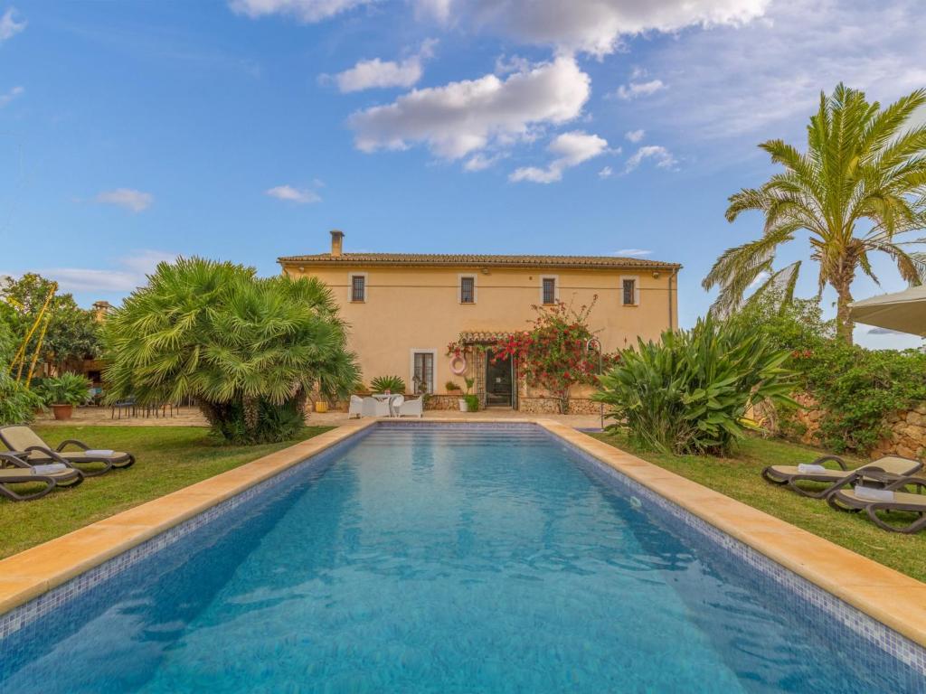a villa with a swimming pool in front of a house at Antonio in Mallorca with Bay Views in Búger