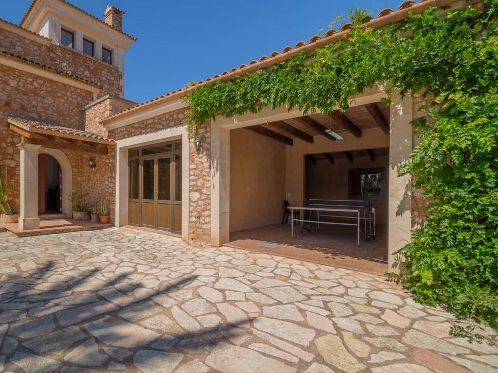 a patio of a house with a table and vines at Palleta S'Horta near Cala Mondragó Beach in Felanitx