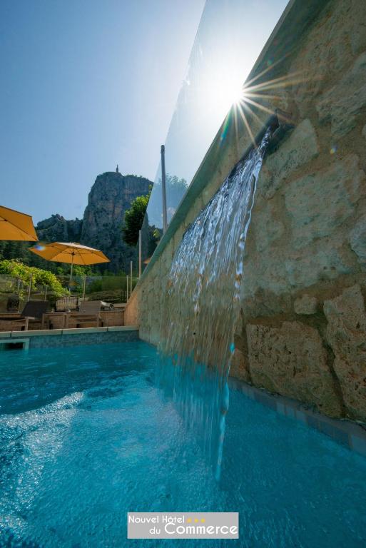 une piscine avec une fontaine à eau dans l'établissement Nouvel Hôtel du Commerce, à Castellane
