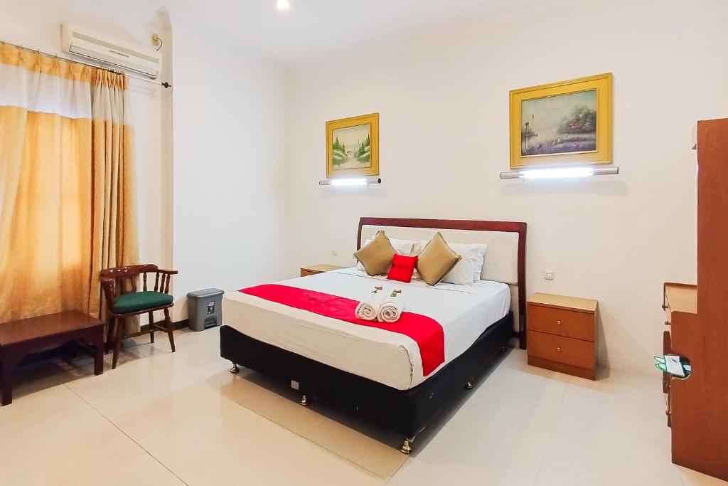 een slaapkamer met een bed en een stoel erin bij RedDoorz near Focal Point Medan in Sunggal