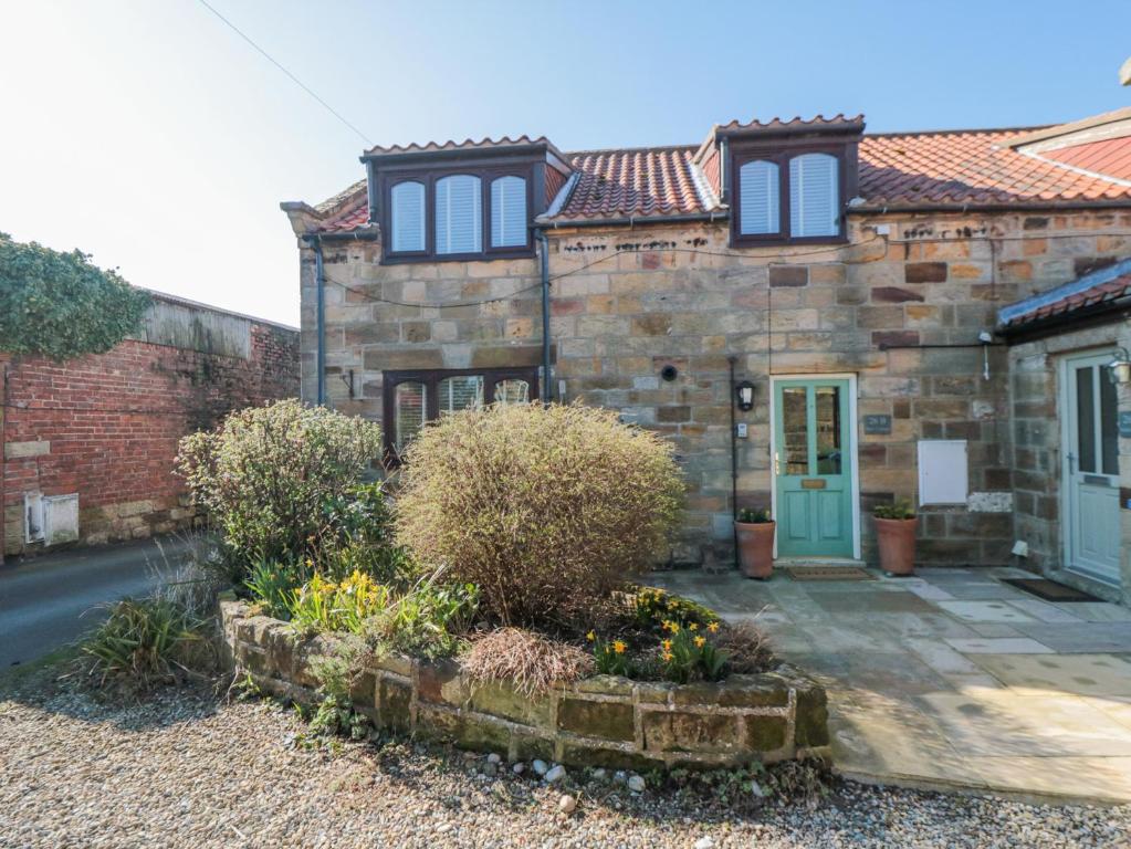 an old stone house with a blue door at Barn Cottage in Saltburn-by-the-Sea