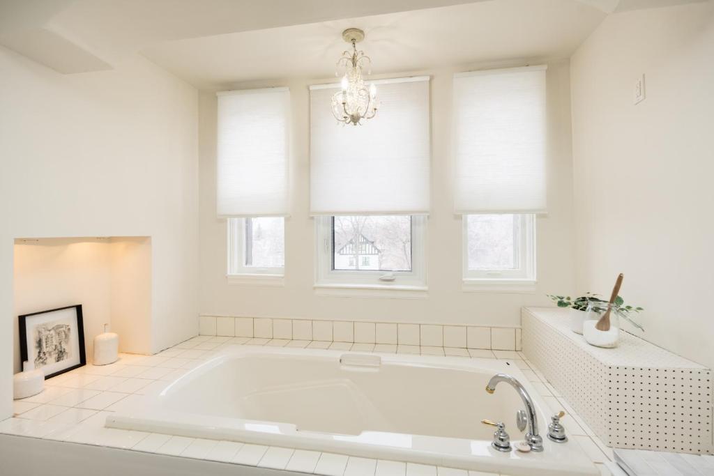 a white bathroom with a tub and windows at No. 5 East in Winnipeg