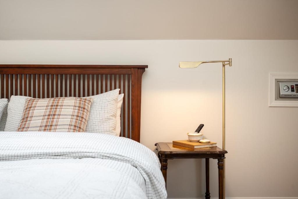 a bedroom with a bed and a table with a lamp at No. 5 East in Winnipeg